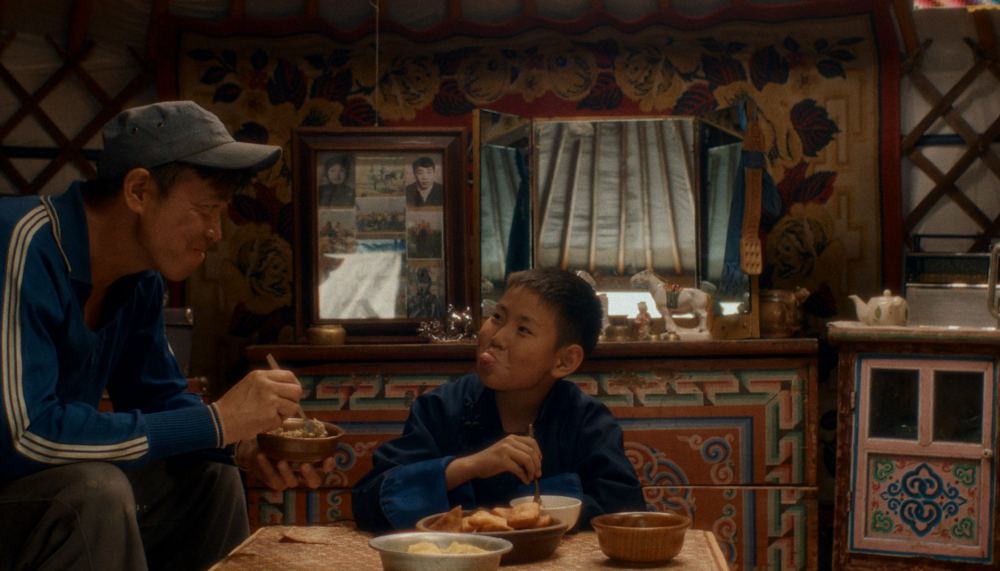 Balgaa and the boy share a meal in the ger